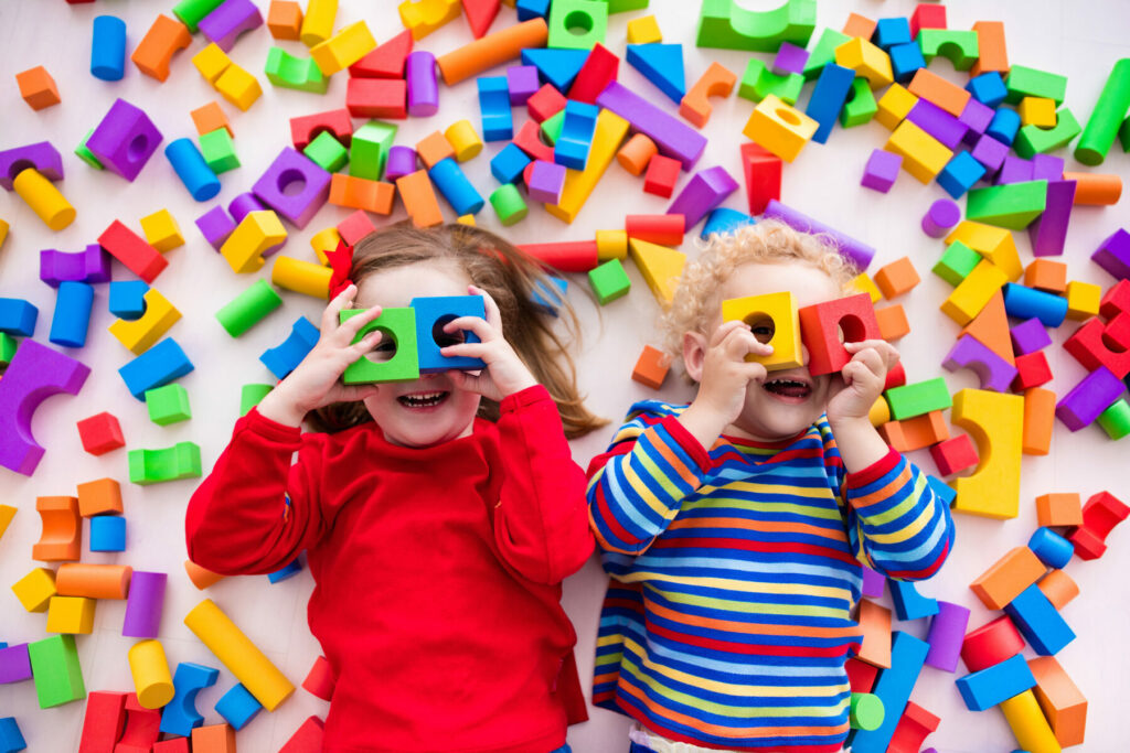 Happy children playing with toy bricks